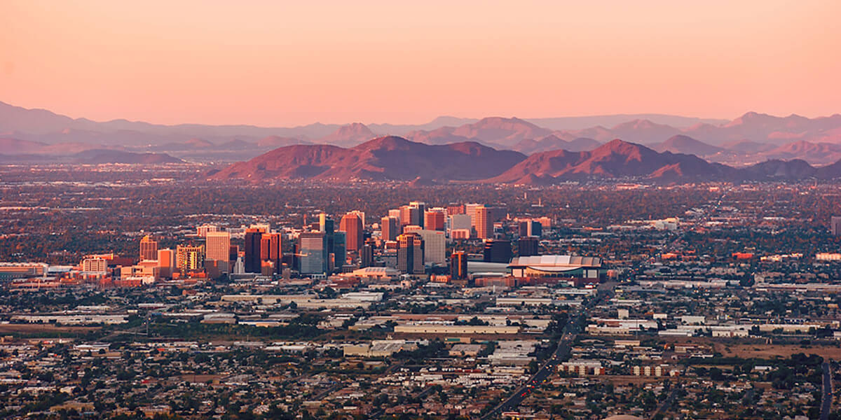 Phoenix Arizona with its downtown lit by the last rays of sun at dusk.
