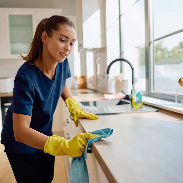 Professional cleaner wiping a kitchen countertop